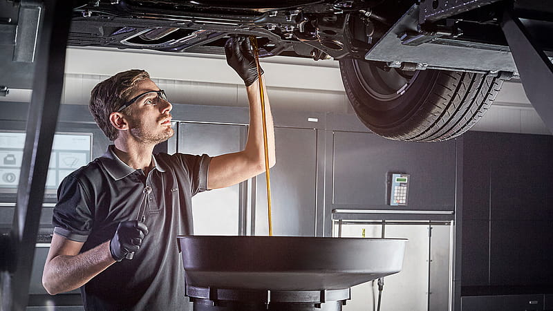 Man talking with mechanic at car garage